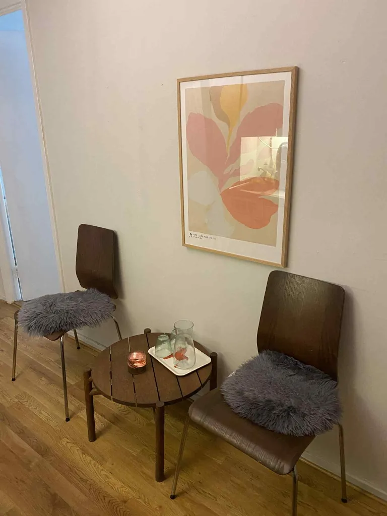 Lugn väntplats i Örebro med fåtöljer, litet bord och inramad konst